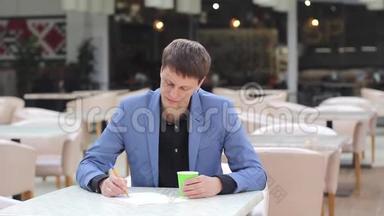 年轻的企业家在咖啡馆里写一份<strong>商业计划书</strong>